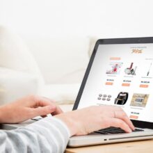 Pessoa navegando em notebook por uma lista online de presentes de casamento, com itens domésticos e valores exibidos na tela.