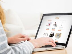 Pessoa navegando em notebook por uma lista online de presentes de casamento, com itens domésticos e valores exibidos na tela.