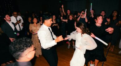 Noivos dançando animados no centro da pista enquanto convidados comemoram ao redor, ilustrando a escolha de músicas para casamento animar a festa.