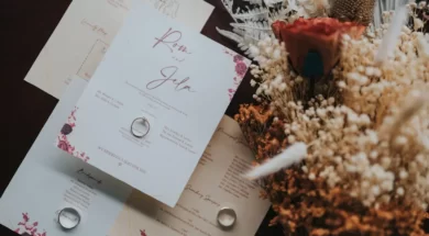 Imagem de convites de casamento com um anel sobre eles e, ao lado, flores decorativas