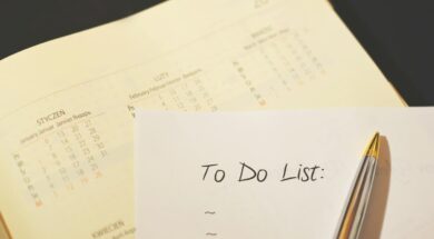 Folha com a inscrição “To Do List” ao lado de um calendário e uma caneta, representando uma lista de preparativos para casamento.