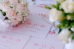 Imagem mostra convites de casamento com a data em destaque. Ao lado, há um buquê de flores.