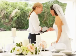 Imagem de uma noiva em seu casamento conversando com a cerimonialista.