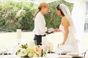 Imagem de uma noiva em seu casamento conversando com a cerimonialista.