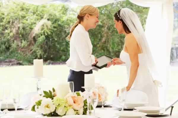 Imagem de uma noiva em seu casamento conversando com a cerimonialista.
