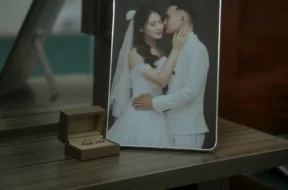 Fotografia dos noivos e uma caixa com aliança.