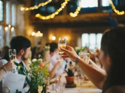 Convidados celebram casamento com taças de espumante à mesa