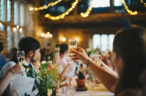 Convidados celebram casamento com taças de espumante à mesa