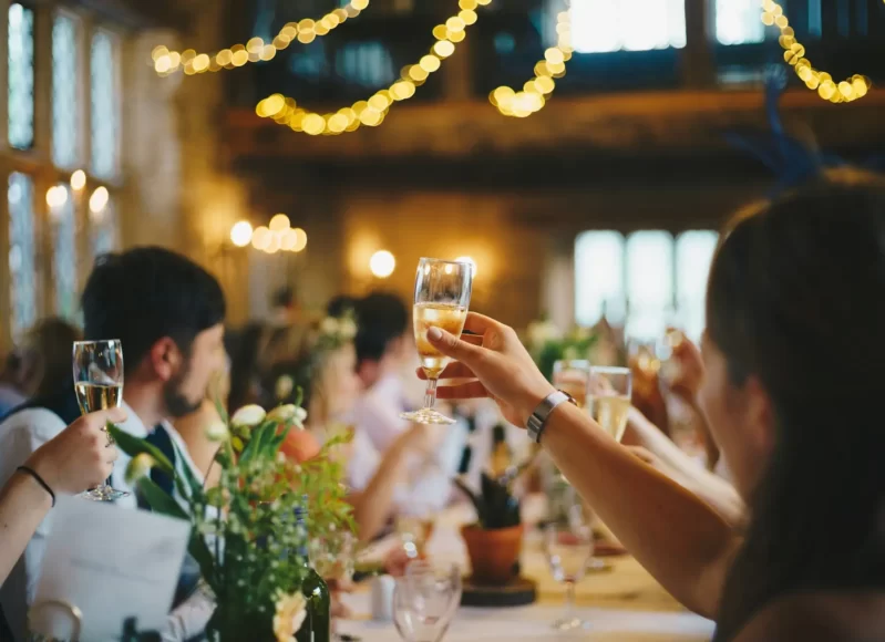 Convidados celebram casamento com taças de espumante à mesa