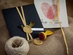 Convite de casamento com envelope preto, lacre de cera dourado e fita de cetim.