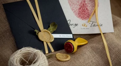 Convite de casamento com envelope preto, lacre de cera dourado e fita de cetim.