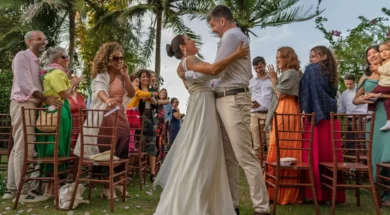 Noivos se abraçam durante cerimônia de casamento ao ar livre, cercados por convidados em um jardim.